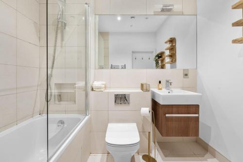 a bathroom with a toilet and a tub and a sink at Apartment - Sleeps 2 - Parking - Great Location in Isleworth