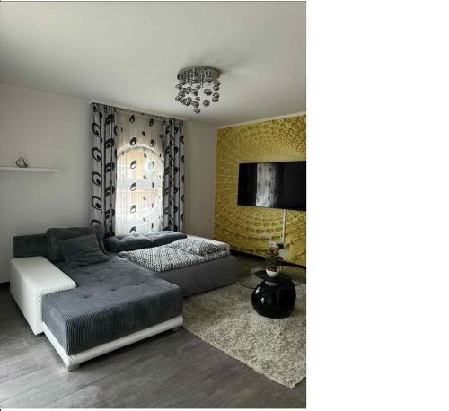 a living room with a bed and a tv at Mimi Apartman in Debrecen