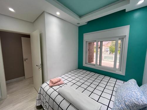 ein Schlafzimmer mit einem Bett und einem Fenster in der Unterkunft Casa de Alto Padrão Verdes Campos POA in Porto Alegre