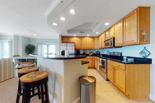 a large kitchen with wooden cabinets and bar stools at Condo 4100 #201 in Ocean City