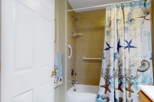 a bathroom with a shower curtain with mermaids on it at Condo 4100 #201 in Ocean City