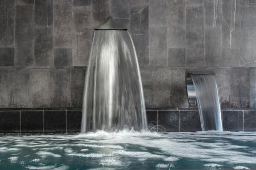 a water fountain in front of a stone wall at Eurostars Valladolid in Valladolid