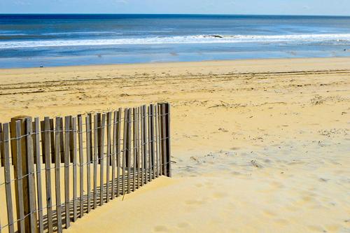 a fence on a sandy beach with the ocean at Condo 4100 #201 in Ocean City