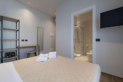 a bedroom with a bed and a tv and a bathroom at Global Hotel in Rimini