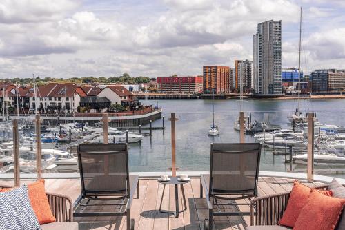 a balcony with chairs and a marina with boats at Harbour Hotel & Spa Southampton in Southampton