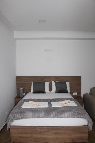 a bedroom with a large bed with a wooden headboard at AMD - garsonjera 312 in Dobra Voda