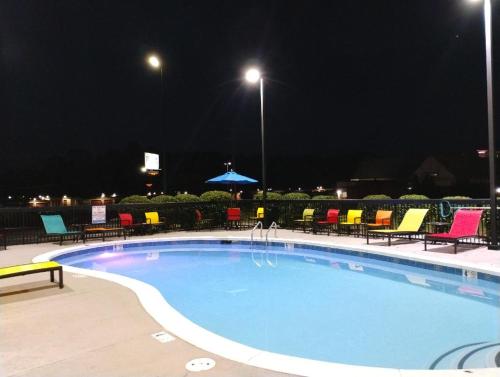 a swimming pool at night with colorful chairs and tables at Hampton Inn by Hilton in Hot Springs, Arkansas in Hot Springs