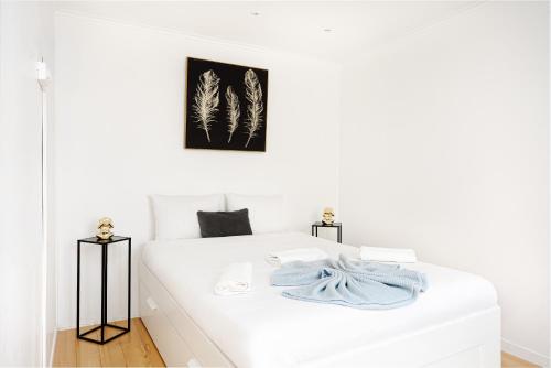 - une chambre avec un lit blanc et une couverture dans l'établissement Center Paris République Appartment, à Paris