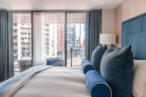 a bedroom with a bed with a large window at Harbour Hotel & Spa Southampton in Southampton