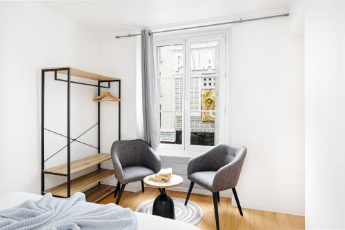 - une chambre avec 2 chaises, une table et une fenêtre dans l'établissement Center Paris République Appartment, à Paris