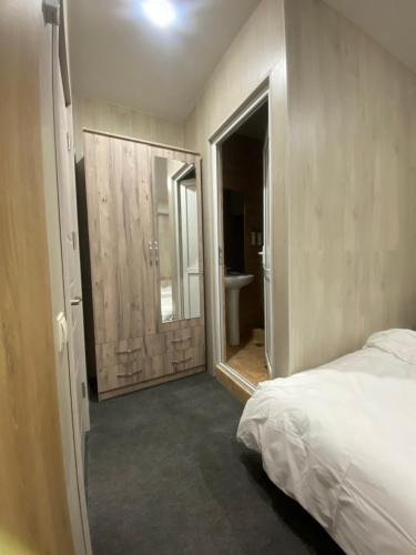 a bedroom with a bed and a bathroom with a mirror at Mountain breeze in Lagodekhi