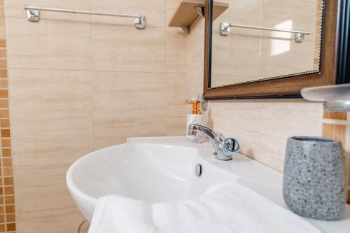a bathroom with a white sink and a mirror at Villa Yucca in Vlorë