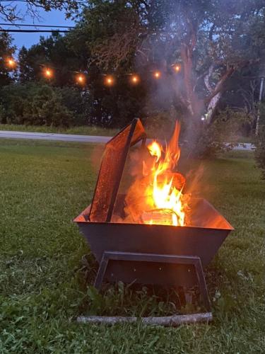 a fire pit in the grass in a park at night at Gite de la Baie Hatée in Bic