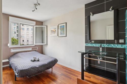 ein Schlafzimmer mit einem Bett, einem Waschbecken und einem Spiegel in der Unterkunft Charmant Appartement T2 - Garage in Villeurbanne
