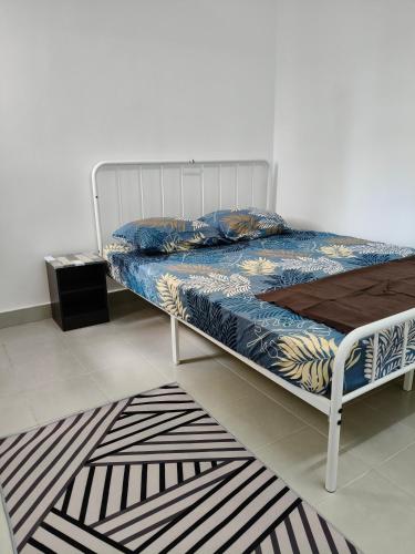 a bed in a room with a rug at NurrCha Homestay Afamosa near WaterparklHondalUniKL in Kampong Pulau Sebang