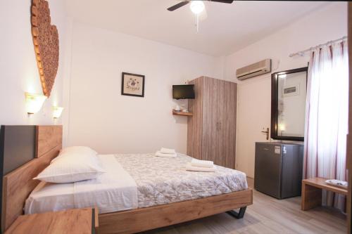 a small bedroom with a bed and a television at SKYROS AVRA Residences in Skiros