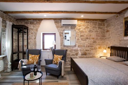 a bedroom with a bed and two chairs at Studio ANIMA GENOVESE - Old Town Rovinj - sea view in Rovinj