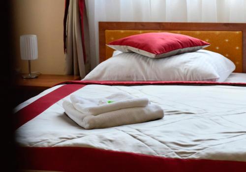 a bed with two towels and pillows on it at Hotel Dukat in Biała Podlaska