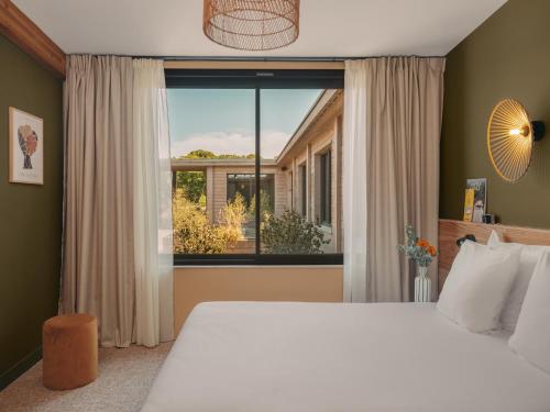 Ένα ή περισσότερα κρεβάτια σε δωμάτιο στο Hôtel le Bout du Parc de Versailles