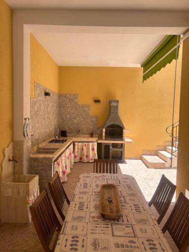 a kitchen with a table with chairs and a stove at Casa Martina in Tre Fontane