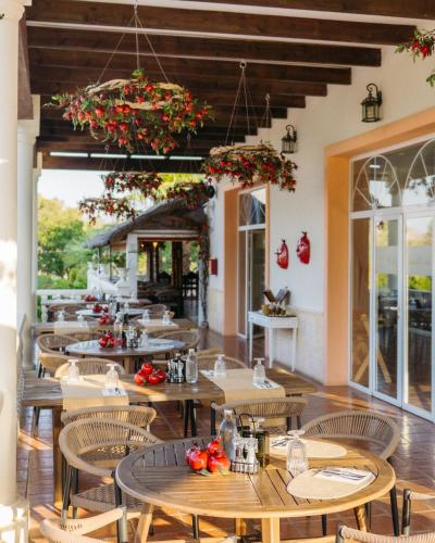 un restaurante con mesas de madera, sillas y flores en Hotel La Plantación, en Finestrat