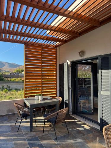 リバディオンにあるBlue Opal House in Livadi Beach Serifosの木製パーゴラ、テーブル、椅子付きのパティオ