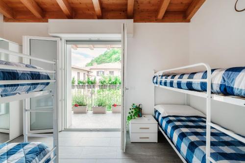 a room with bunk beds and an open door at Casa Malù in Mandello del Lario