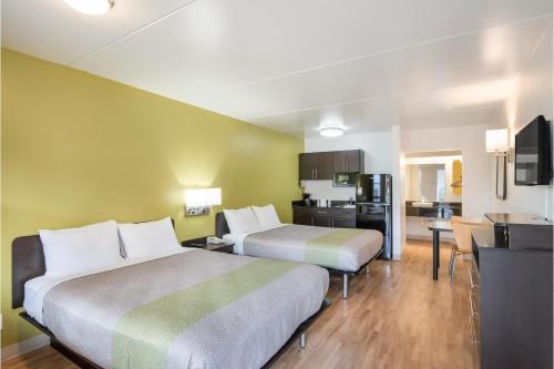 a hotel room with two beds and a kitchen at Studio 6 Colorado Springs, Colorado - Air Force Academy in Colorado Springs