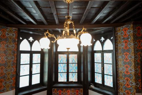 a chandelier is hanging in a room with windows at Kulla Inglizit in Shkodër