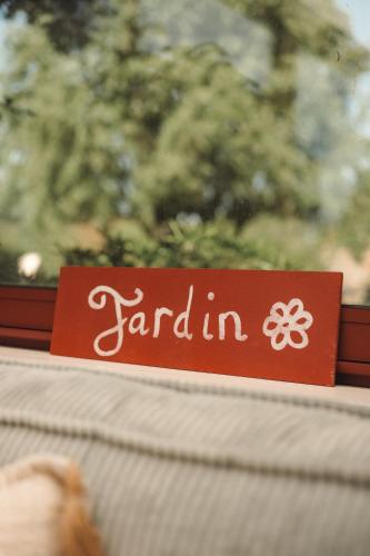 a red sign that says garden in on a window at Hôtel Les Voisins Beaucemaine in Ploufragan