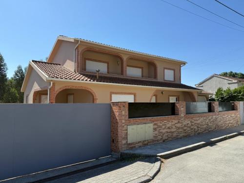 a house with a brick fence in front of it at Pousada starlite in Regilde