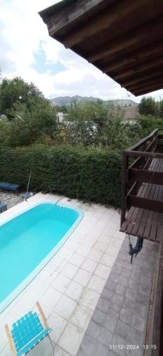 a swimming pool with two lawn chairs and a bench at Entrepinos I in Juana Koslay 