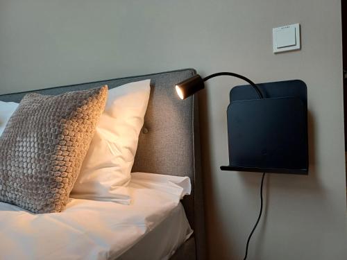 a bed with a pillow and a lamp on a wall at Luise LuXe Suites in Tallinn