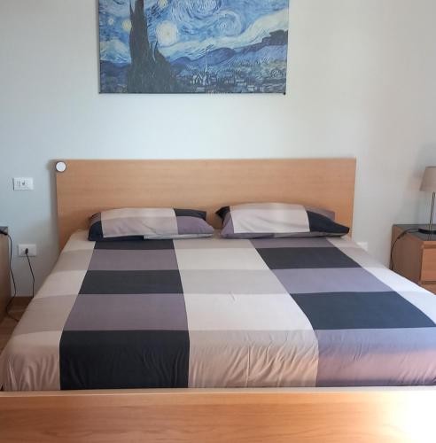 a bedroom with a bed and a painting on the wall at Bed&Breakfast Bella Vita in Moneglia