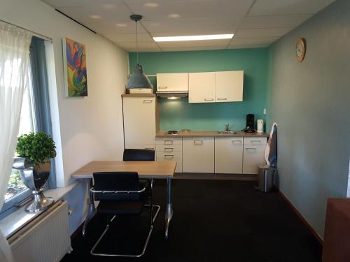 a kitchen with a table and chairs in a room at Appartement De Molshoop II in Landsmeer