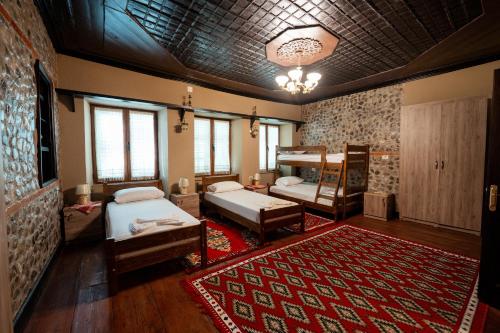 a bedroom with two beds and a red rug at Kulla Inglizit in Shkodër