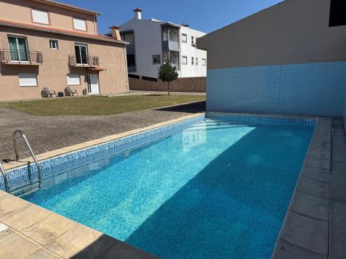 a large blue swimming pool next to a building at Pousada starlite in Regilde