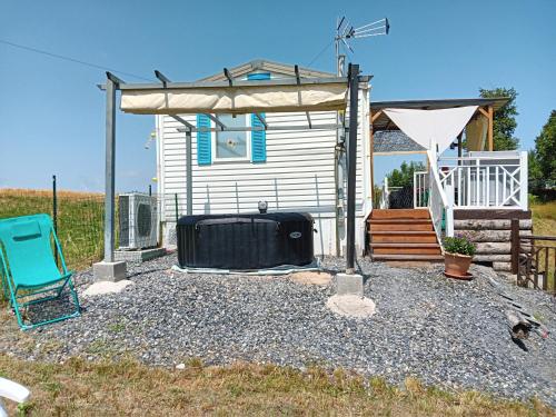 a tent and a chair in front of a house at ROUPILLON A JANET in Curvalle