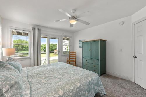 a bedroom with a bed and a ceiling fan at Rx To Relax in Duck