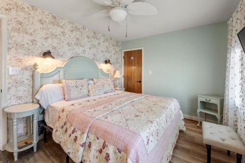a bedroom with a large bed with a pink bedspread at Rose Cottage in Rodanthe