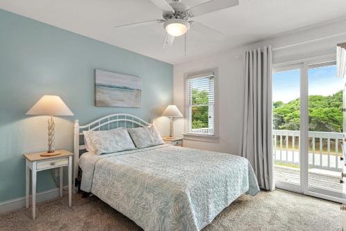 a bedroom with a bed and two windows and a balcony at Rx To Relax in Duck