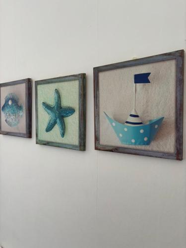 four pictures on a wall with a picture of a boat at The Beach Hotel in Minehead