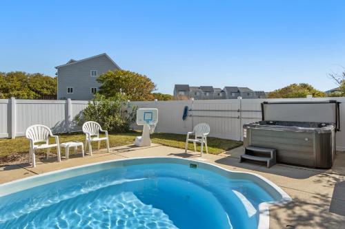 a backyard with a swimming pool and a grill at Rx To Relax in Duck