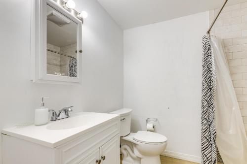 a white bathroom with a sink and a toilet at 10 Mi to Hartford Family Home with Yard in Manchester