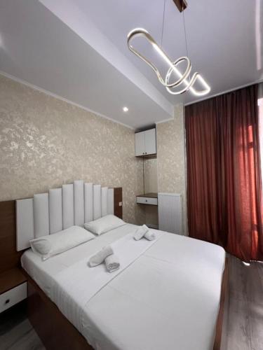 a bedroom with a large white bed with towels on it at Comfort class apartment 10 in Kutaisi