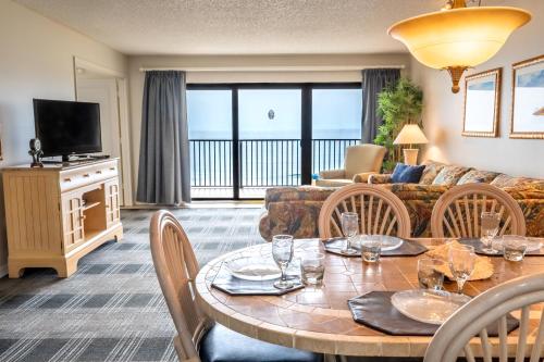 ein Wohnzimmer mit Tisch und Couch in der Unterkunft Las Olas Beach Club of Satellite Beach in Satellite Beach