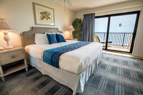ein Schlafzimmer mit einem großen Bett und einem großen Fenster in der Unterkunft Las Olas Beach Club of Satellite Beach in Satellite Beach