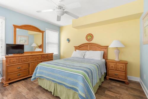 una camera da letto con un letto, un comò e uno specchio di Sandy Bottoms a Nags Head