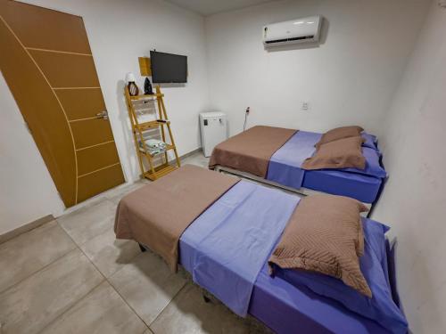 Una habitación con dos camas y un televisor. en Casa do Calico em Fernando de Noronha!, en Fernando de Noronha