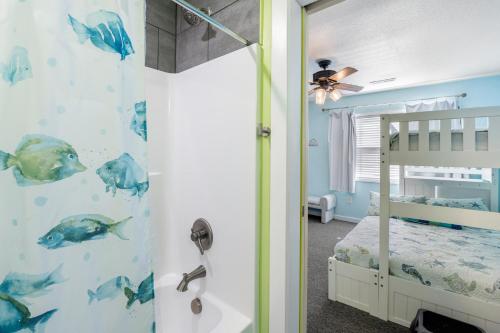 Una habitación infantil con un dormitorio con cama y ducha. en Seawalk Condos, en Kill Devil Hills